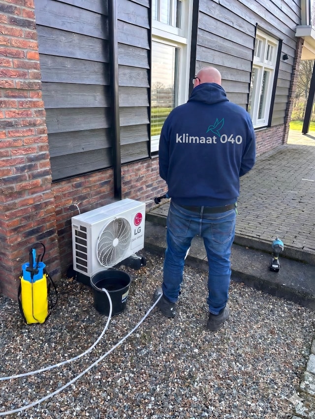 Klimaat 040 technician cleaning an outdoor AC unit